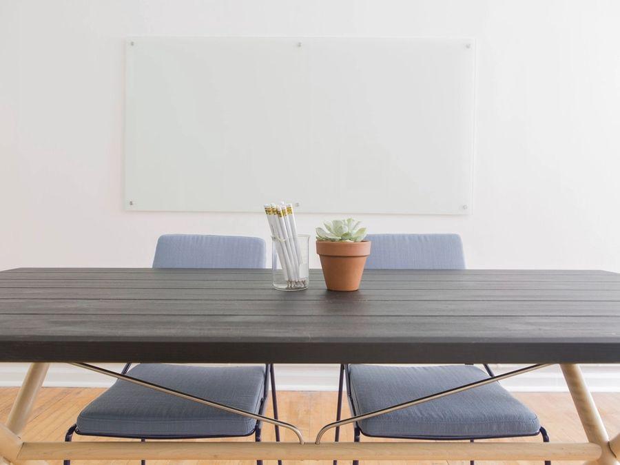 Sala de reunião com mesa de madeira e cadeiras